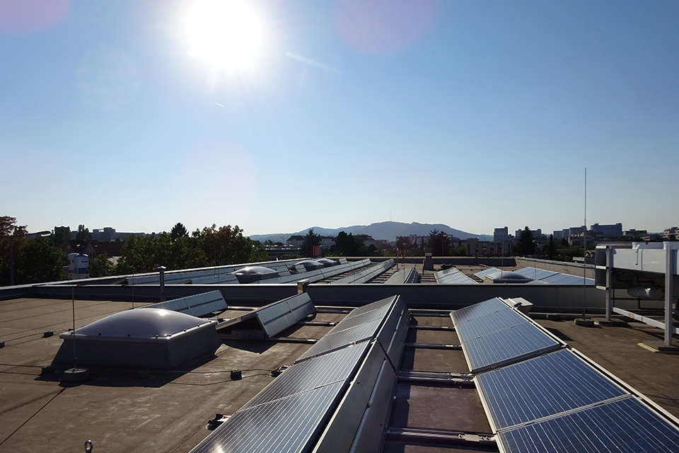 Von der Sonne beschienene Photovoltaikanlagen auf einem Flachdach.